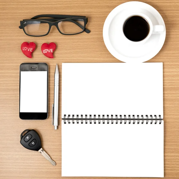 Office desk : coffee and phone with car key,eyeglasses,notepad,h