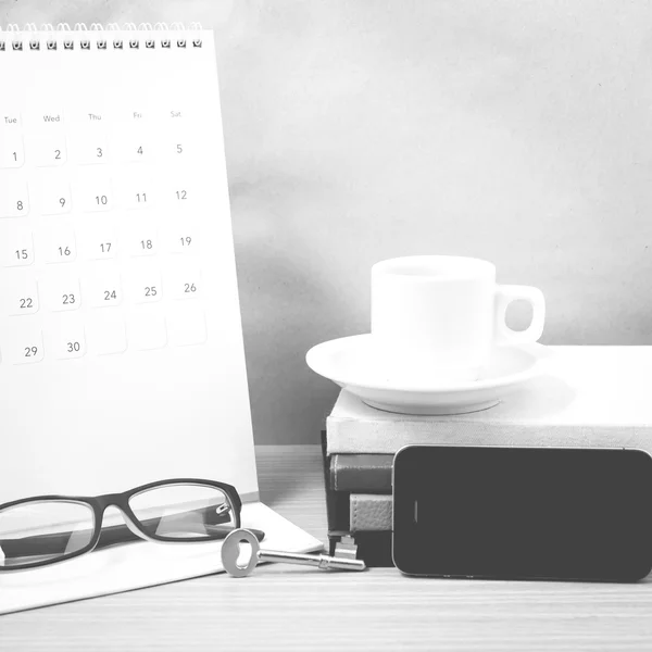 Coffee and phone with key,eyeglasses,stack of book,calendar blac