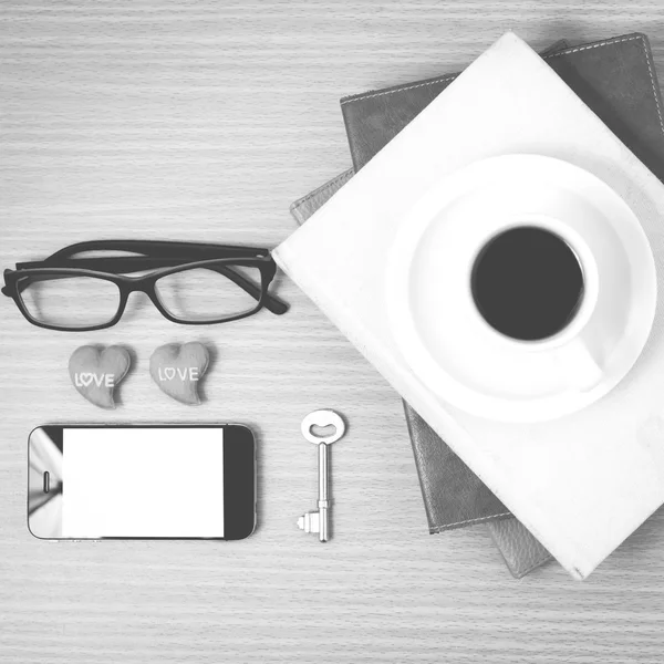 Office desk : coffee and phone with key,eyeglasses,stack of book