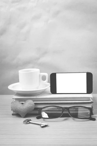 Office desk : coffee and phone with key,eyeglasses,stack of book