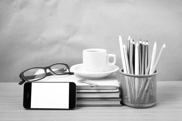 Office desk : coffee and phone with key,eyeglasses,stack of book