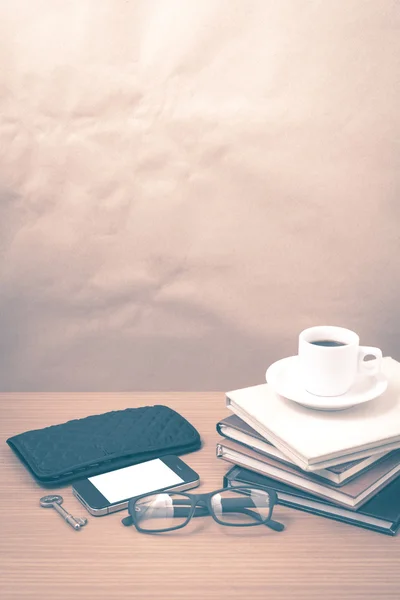 Coffee and phone with stack of book,key,eyeglasses and wallet vi