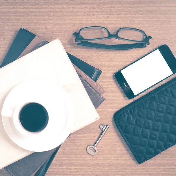 Coffee and phone with stack of book,key,eyeglasses and wallet vi
