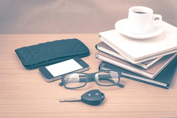 Coffee and phone with stack of book,car key,eyeglasses and walle