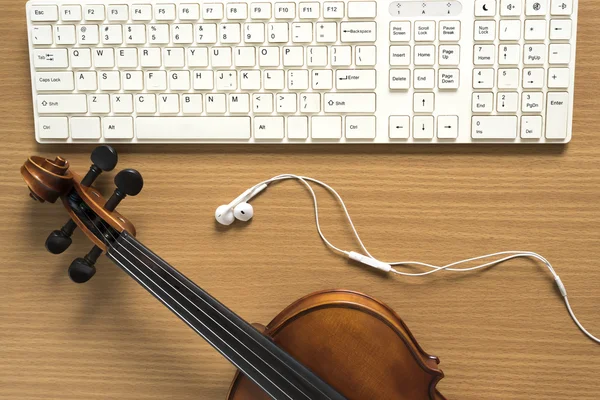 Top view of violin with computer keyboard and earphone