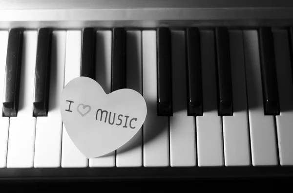 Paper heart on piano keyboard black and white