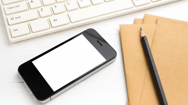 Computer and cellphone with brown paper and pencil