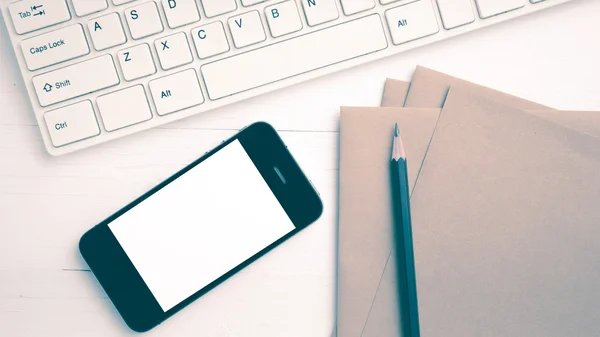 Computer and cellphone with brown paper and pencil vintage style