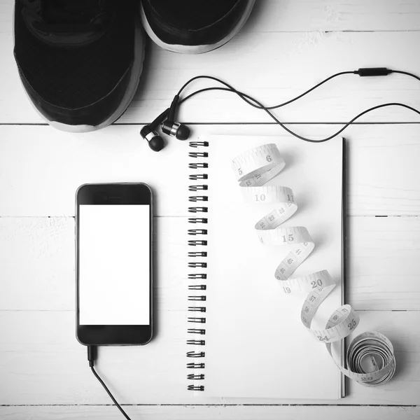 Running shoes,measuring tape,notebook and phone black and white