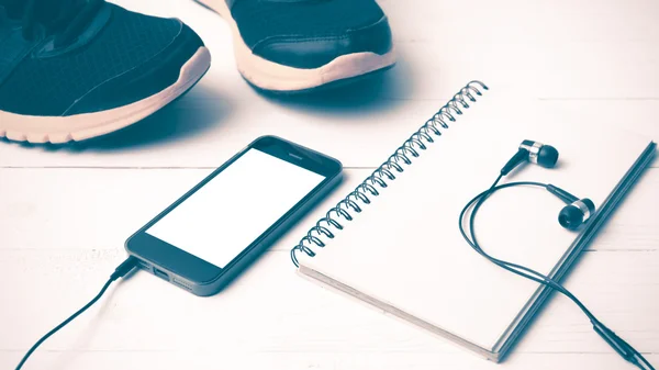 Running shoes,notebook and phone vintage style