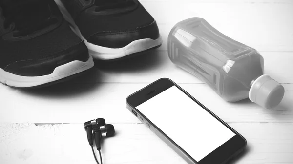Running shoes,orange juice and phone black and white tone color