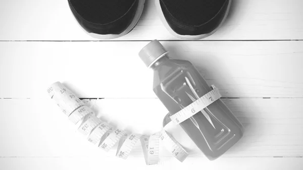 Running shoes,orange juice and phone black and white tone color
