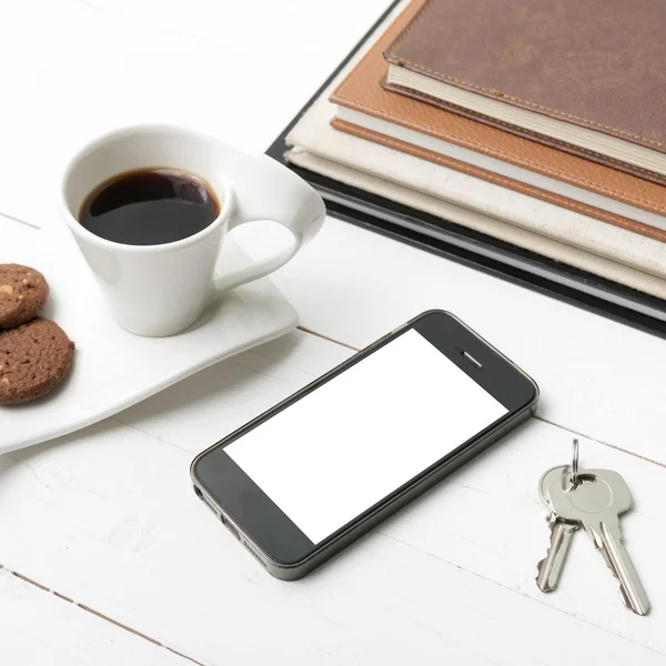 Coffee cup with cookie,phone,stack of book and key