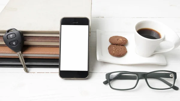 Coffee cup with cookie,phone,stack of book and car key