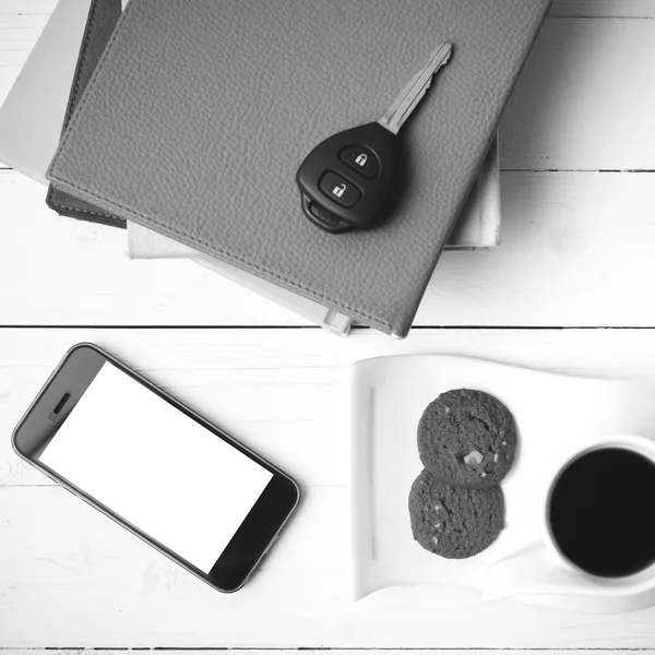 Coffe cup with cookie,phone,car key and stack of book black and