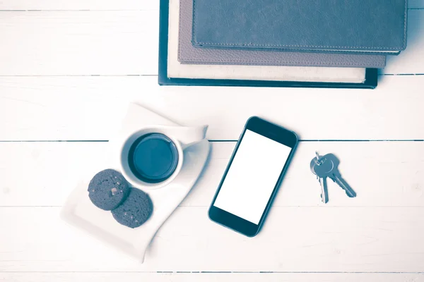 Coffee cup with cookie,phone,stack of book and key vintage style