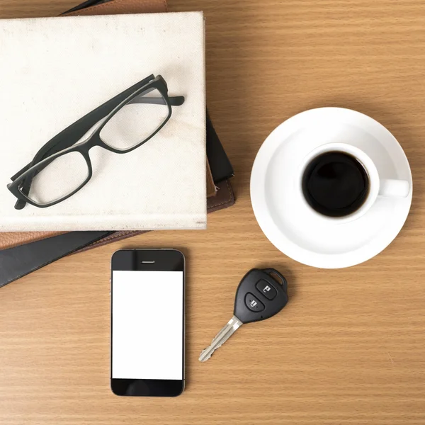 Coffee,phone,car key,eyeglasses and stack of book