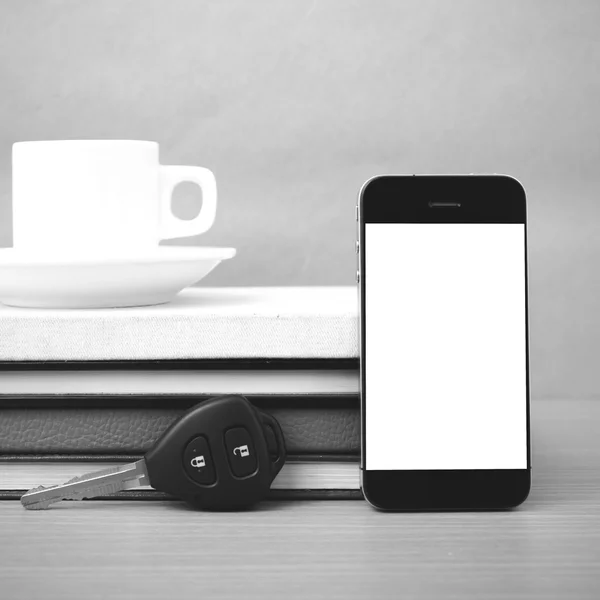 Coffee cup with phone car key and stack of book