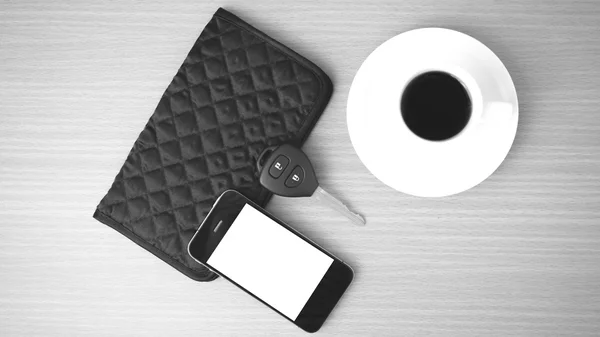 Coffee cup with phone car key and wallet