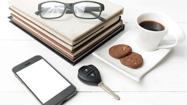 Coffee cup with cookie,phone,stack of book and car key