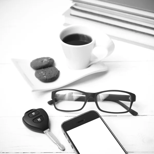Coffe cup with cookie,phone,car key,eyeglasses and stack of book