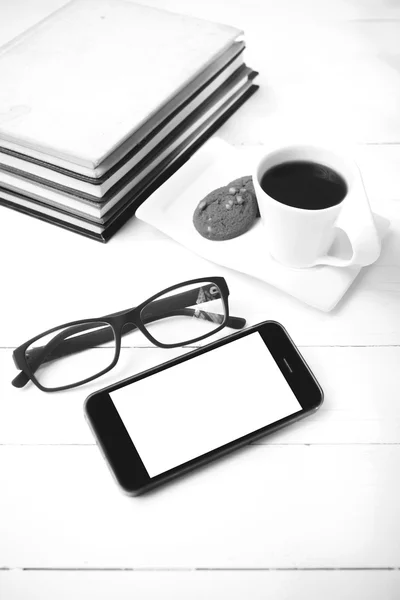 Coffee cup with cookie,phone,stack of book and eyeglasses black