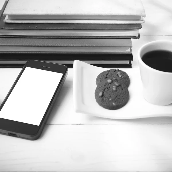 Coffee cup with cookie,phone,stack of book and eyeglasses black