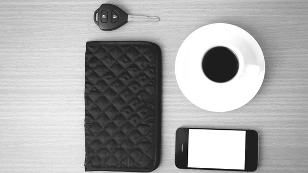 Coffee cup with phone car key and wallet