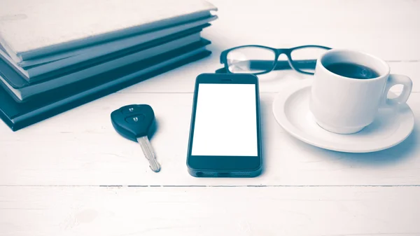 Coffee cup with phone, car key,eyeglasses and stack of book vint