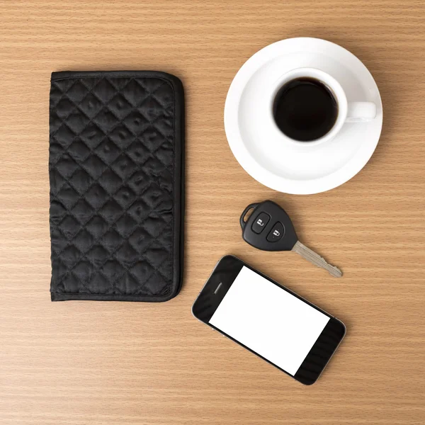 Coffee cup with phone car key and wallet