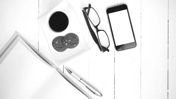 Coffee cup with cookie,phone,notebook and eyeglasses black and w