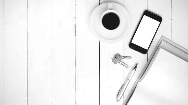 Coffee cup with phone, key and open notebook black and white col