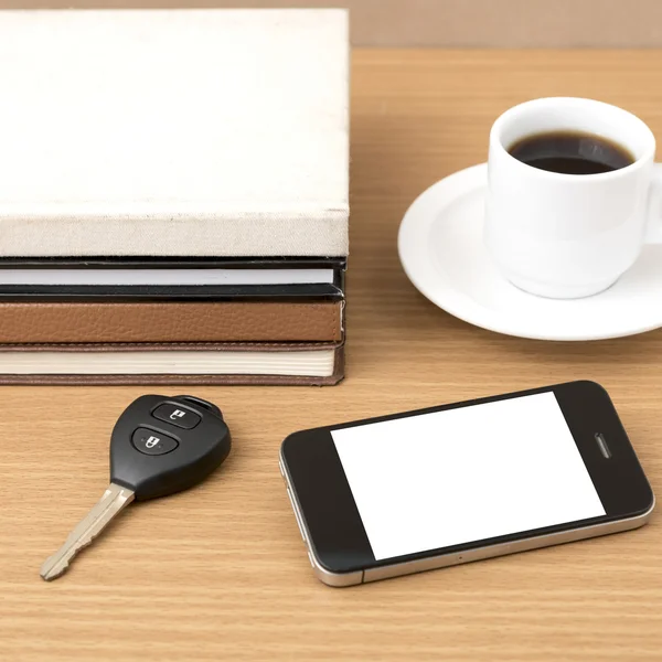 Coffee cup with phone car key and stack of book