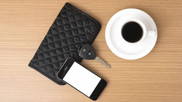 Coffee cup with phone car key and wallet