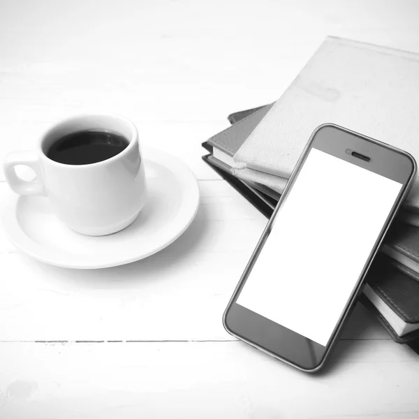 Coffee cup with phone and stack of book black and white color