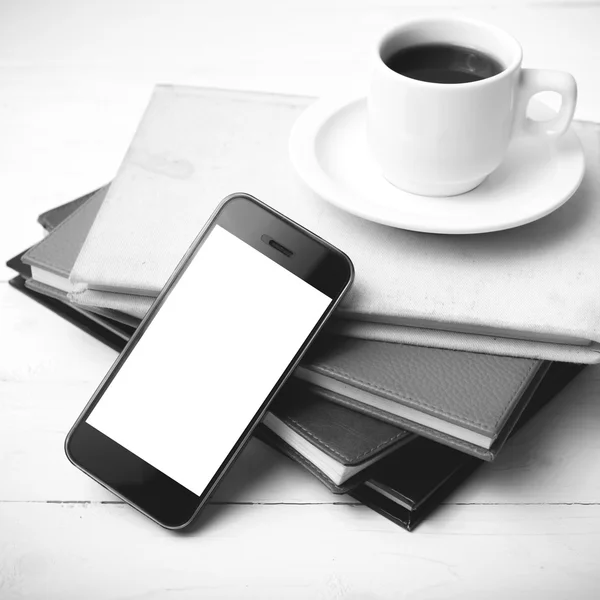 Coffee cup with phone and stack of book black and white color