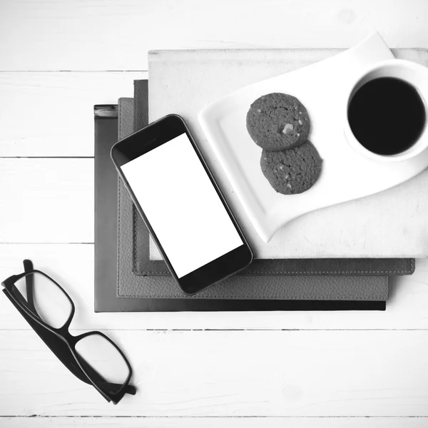 Coffee cup with cookie,phone,stack of book and eyeglasses black