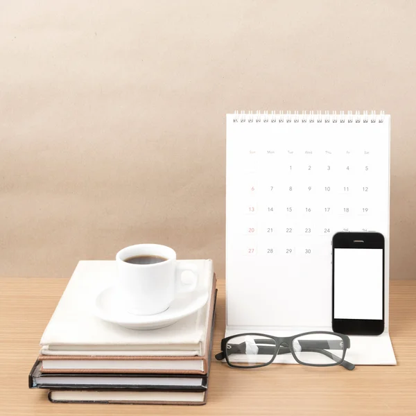 Coffee,phone,eyeglasses,stack of book and calendar