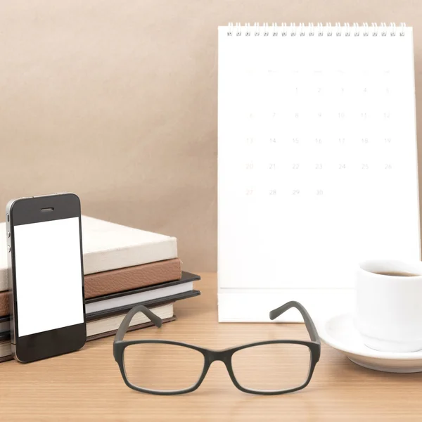 Coffee,phone,eyeglasses,stack of book and calendar