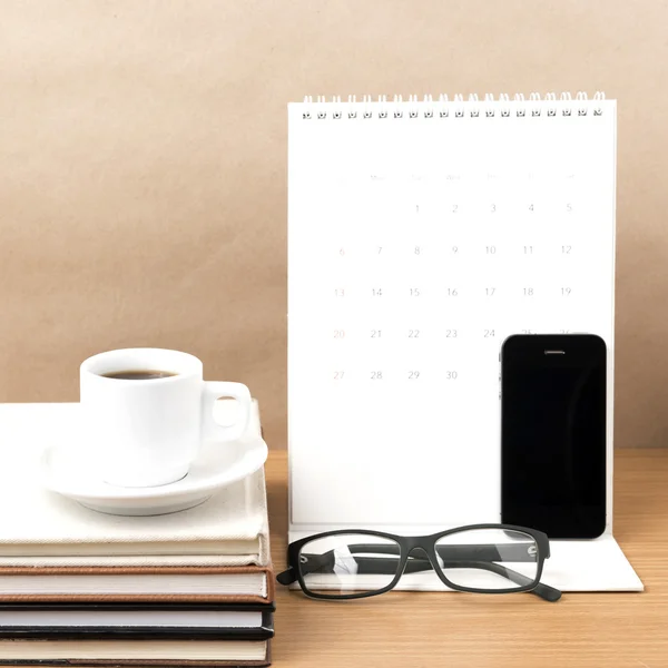 Coffee,phone,eyeglasses,stack of book and calendar