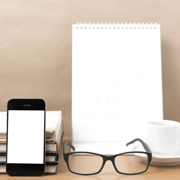 Coffee,phone,eyeglasses,stack of book and calendar