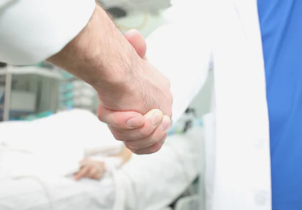 Doctors handshake concept of cooperation in patient treatment
