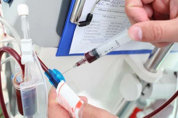 Doctor collects blood from the medical device