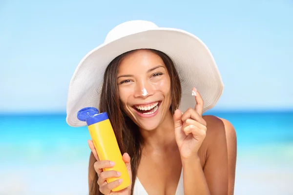 Woman applying suntan lotion