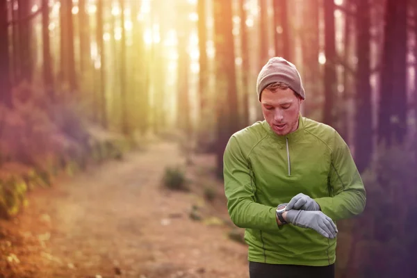 Runner looking at heart rate monitor watch