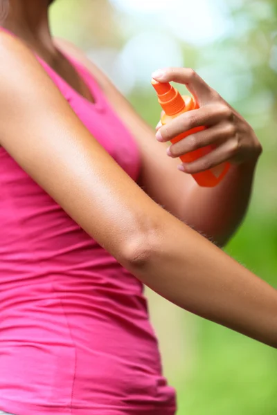 Woman spraying insect repellents on skin