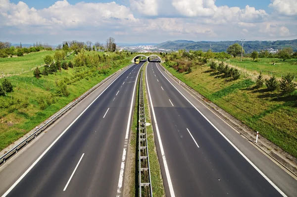 Corridor highway with the transition for wildlife, passing under ecoduct yellow truck