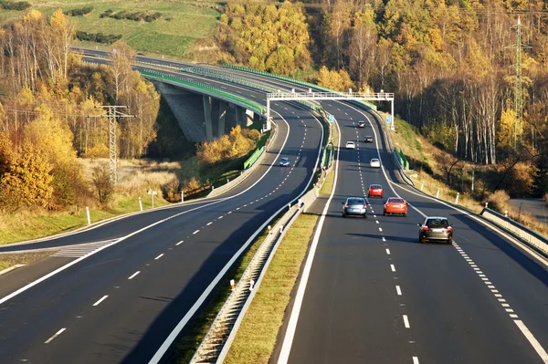 Cars on the highway leading across the bridge over the valley, electronic toll gates, top view