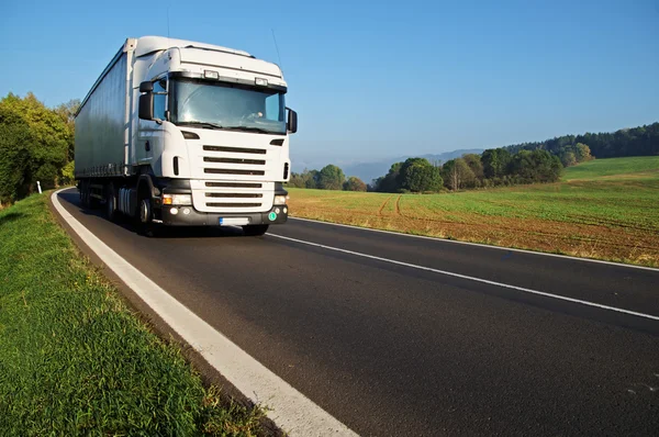 White truck on the road in the countryside