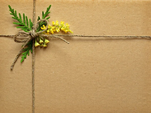 Cardboard tied with small wild flowers bouquet and rope